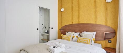 Una habitación de hotel con una cama grande, un cabecero de madera y un espejo en la pared.