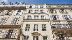 A multi-story building with a classic architectural style, featuring symmetrical windows and balconies. - New Apartment Center of Paris/le Marais (Paris)