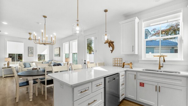 A modern kitchen with white cabinetry, a large island, and pendant lighting. - BRAND NEW CONSTRUCTION! CLOSE TO BEACH!  PET FRIENDLY! 3/2 SLEEPS 6! (Panama City Beach)