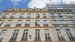 Un edificio a più piani in stile architettonico classico, con finestre regolarmente distanziate e balconi decorativi.