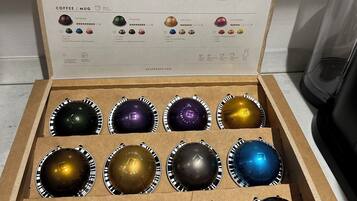 A box of Nespresso coffee capsules with a variety of flavors and origins.