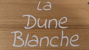 Superficie de madera con la inscripción 'La Dune Blanche'.
