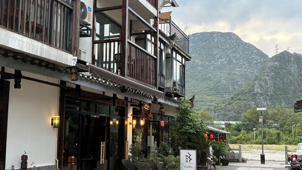 A traditional building with a balcony, potted plants, and a signboard. - Castle peak yard Inn Guilin (Guilin)