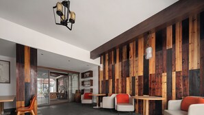 A modern interior with a wooden accent wall, seating area, and a ceiling light fixture. - Castle peak yard Inn Guilin (Guilin)