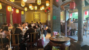 A restaurant interior with traditional decor, including hanging lanterns and wooden furniture. - Castle peak yard Inn Guilin (Guilin)