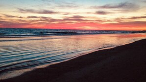 A beach with a sunset over the ocean. - Exquisite Rooftop Deck Beach View Pool Spacious (St. Pete Beach)