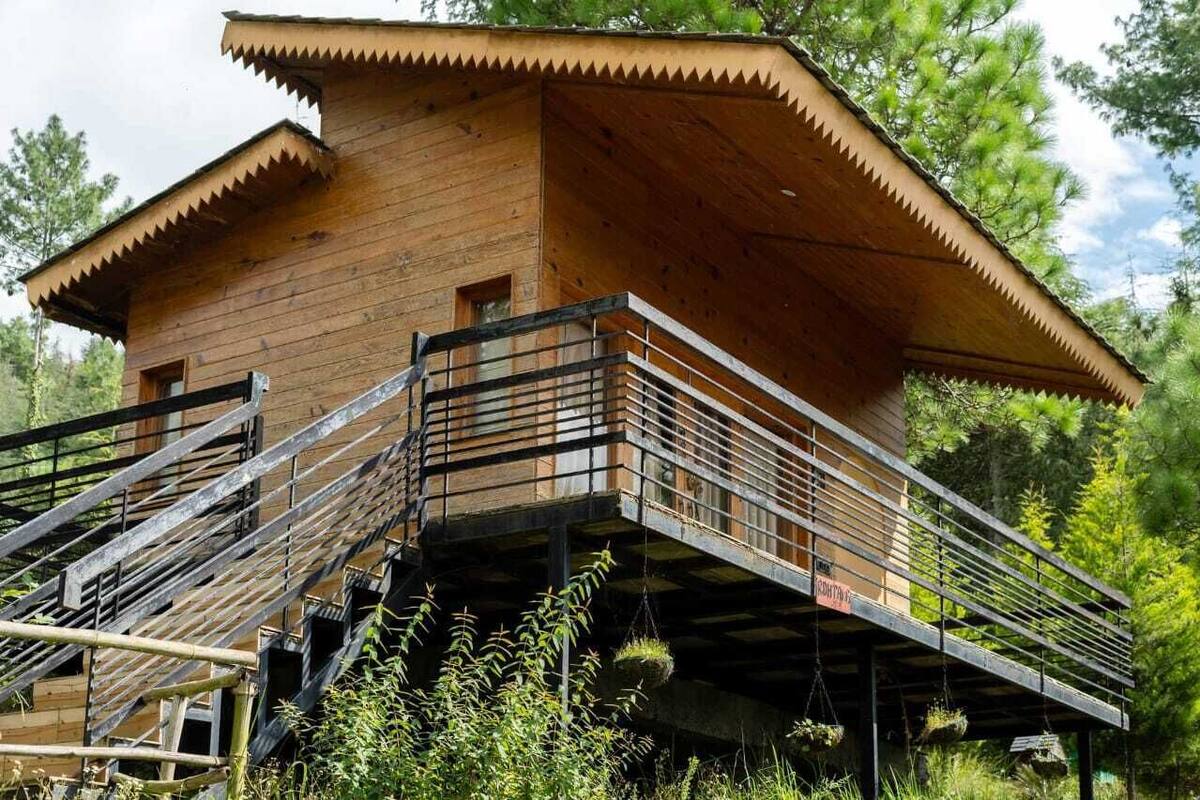 Una cabaña de madera con balcón y escaleras.