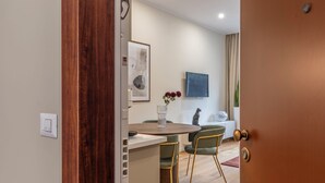 A modern dining area with a round table, two green chairs, and a vase with flowers. - New apartment in central Rome, close to subway, full equiped, king bed, Wifi. (Roma)