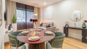 A dining area with a round table, green chairs, and a vase of flowers. - New apartment in central Rome, close to subway, full equiped, king bed, Wifi. (Roma)