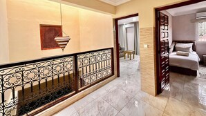A hallway with a marble floor, a decorative wall hanging, and a staircase with a wrought iron railing. - Authentic Riad Dar Adam / Splendid Rooftop & Pool (Marrakech)