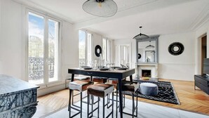Una cucina moderna con un piano di lavoro in marmo, un tavolo da pranzo con sgabelli e un camino.