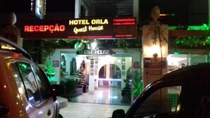 A hotel entrance with a reception desk, a sign for 'Hotel Orla Guest House', and a statue in the background. - Hotel orla Guest House (Petrolina)