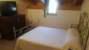 A bedroom with a bed, a dresser, a television, and a window. - DALI HOLIDAY HOME 5 minutes from the sea and the cetacean sanctuary (Imperia)