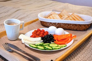 A tray with a plate of food including tomatoes, cucumbers, cheese, eggs, olives, and bread, along with a cup of coffee. - Bucharest Airport Hotel (Otopeni)