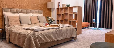 A bedroom with a large bed, a wooden bookshelf, a desk, and a chair.