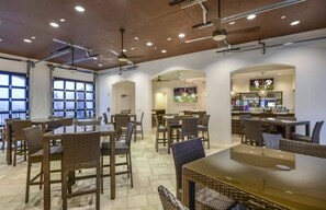 A spacious indoor dining area with multiple tables and chairs, ceiling fans, and large windows. - 5 BD Home near Disney, Lazy River, Game Room(9021) (Kissimmee)