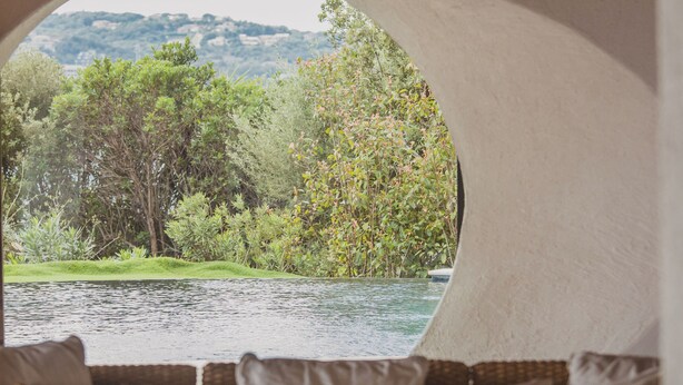 A cozy room with a circular window overlooking a natural landscape. - Luxury Villa with private beach and splendid pool on Sea Front (Porto-Vecchio)
