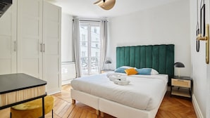 Una camera d'albergo con un letto grande, una scrivania e una finestra con tende.
