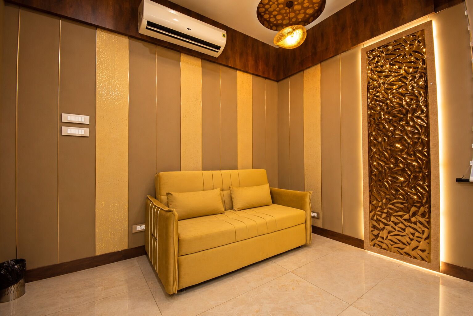 A room with a sofa, an air conditioning unit, a textured wall, and a decorative panel.