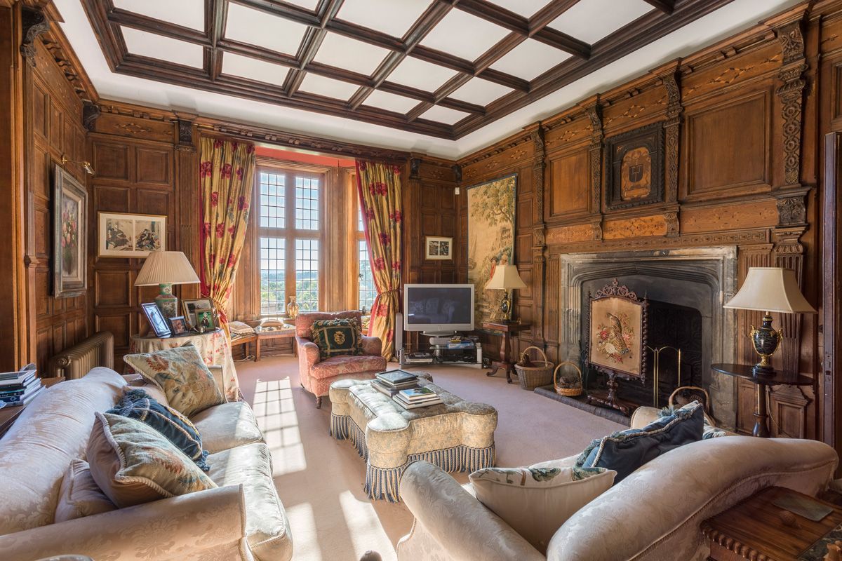 A traditional room with a fireplace, wooden paneling, and classic furniture.