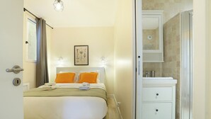 A bedroom with a bed, a bedside table, a nightstand, a bathroom with a sink, and a shower. - Apartement Center of Paris (Paris)