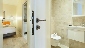 A hotel room with a bed, a bathroom with a toilet and sink, and a door with a handle. - Apartement Center of Paris (Paris)