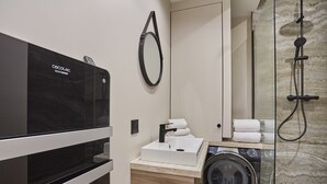 A modern bathroom with a built-in washing machine, a sink, and a shower. - Apartment Center of Paris (Paris)