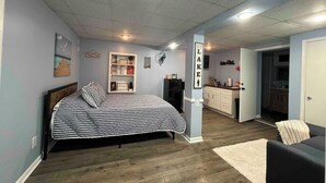 Ein Schlafzimmer mit Bett, Schreibtisch und einer Küchenzeile.
