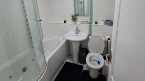 A bathroom with a glass shower enclosure, a bathtub, a sink, and a toilet. - Luxury two bedroom skyline views apartment/Flat (Birmingham)