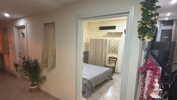 A room with a bed, a potted plant, and a doorway leading to another room. - Crisan B&b Affittacamere (Nola)