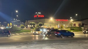 A parking lot with cars and a building with a large sign. - Crisan B&b Affittacamere (Nola)