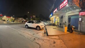 A street view at night with a restaurant named "AFFITTA CAMERE" and a parking lot with several cars. - Crisan B&b Affittacamere (Nola)