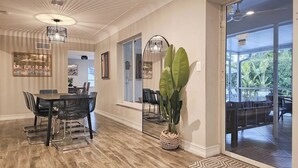 Een ruime eethoek met een hoge plafond, moderne verlichting en een groot raam met uitzicht op het landschap.