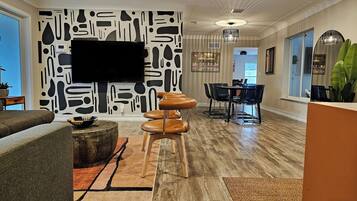 Älytelevisio, pöytätennispöytä, kirjoja, tietokoneen näyttö