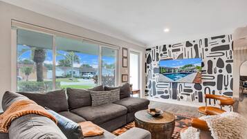 Älytelevisio, pöytätennispöytä, kirjoja, tietokoneen näyttö