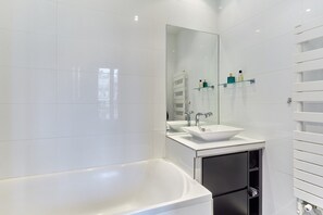 Appartement | Badkamer | Een bad, een haardroger, shampoo