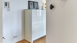Una habitación moderna con un mueble blanco, un teléfono empotrado y una pared decorada con círculos.
