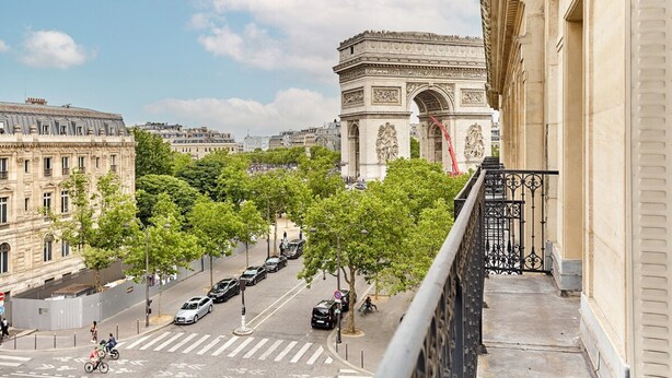 Vista del Arco del Triunfo en París, con una calle en primer plano y edificios a ambos lados.