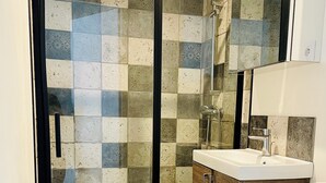 A modern bathroom with a glass-enclosed shower, a wooden vanity, and a white toilet. - Cocooning cottage by the sea  (Longeville-sur-Mer)