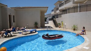A swimming pool with lounge chairs and an inflatable raft. - Peyia, near Paphos, Cyprus - beautiful villa with panoramic view over coral bay  (Peyia)