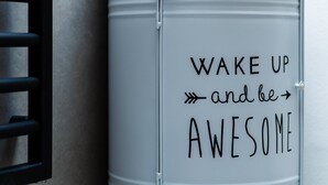 Un contenedor metálico gris con el texto 'WAKE UP and be AWESOME' en un lateral.