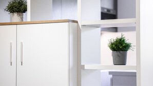 A white wardrobe with two doors and a shelving unit with multiple compartments.