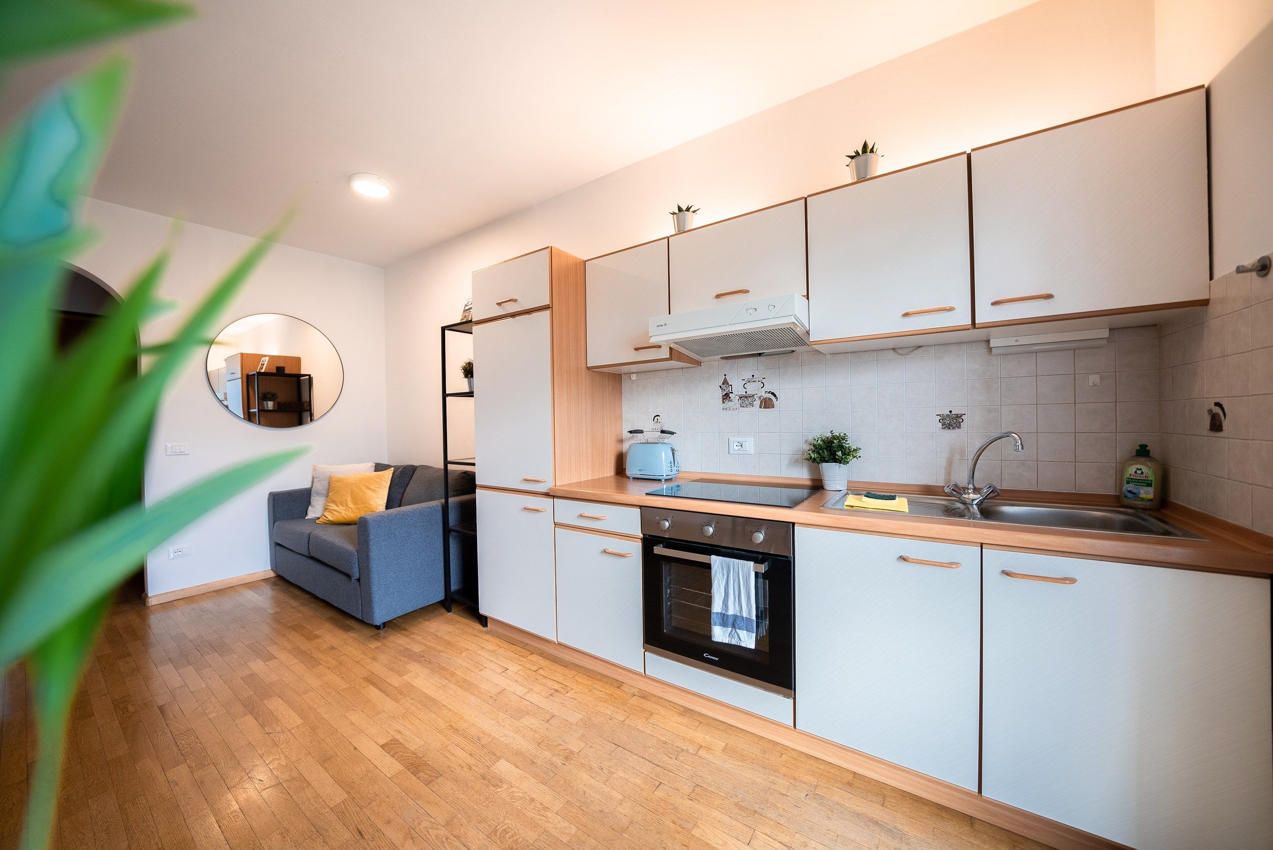 Eine moderne Küche mit weißen Schränken, einem Backofen, einer Spüle und einer Arbeitsplatte mit einem Toaster.