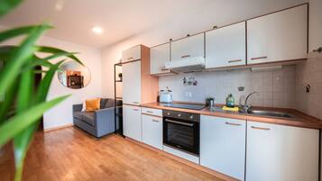Een moderne keuken met houten kasten, een inbouwoven en een spoelbak.