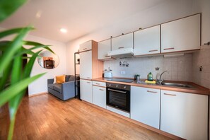 A modern kitchen with wooden cabinets, a built-in oven, and a sink.