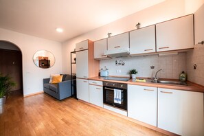 A modern kitchen with white cabinets, a built-in oven, and a sink. - 709A Apartment Schönblick (Caldaro sulla strada del vino)