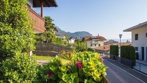 Una calle residencial con casas, un cerco de madera y una montaña al fondo.