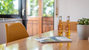 Una mesa con dos botellas de sidra de manzana del Valle del Sur, una revista y una planta en maceta.