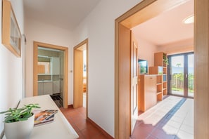 A hallway leading to a kitchen and a balcony with a view. - 714A Apartment Villa Vardia (Caldaro sulla strada del vino)