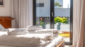 Ein Hotelzimmer mit einem Bett, einem Holzkopfteil und einem Fenster mit Vorhängen.